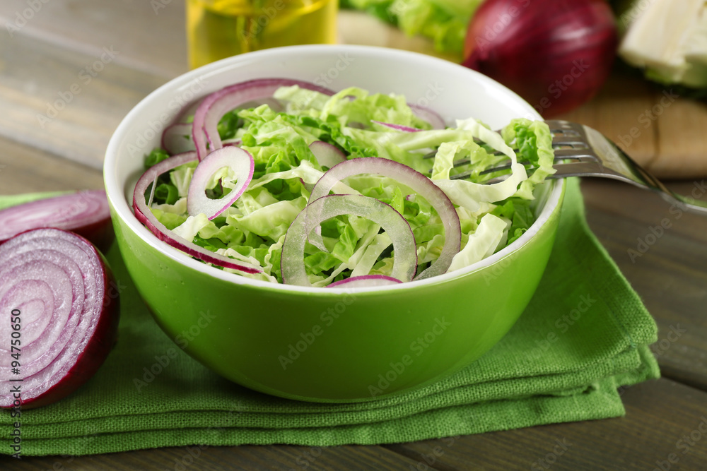 Savoy cabbage and onion salad served in bowl on wooden table Savoy cabbage and onion salad served in bowl on wooden table