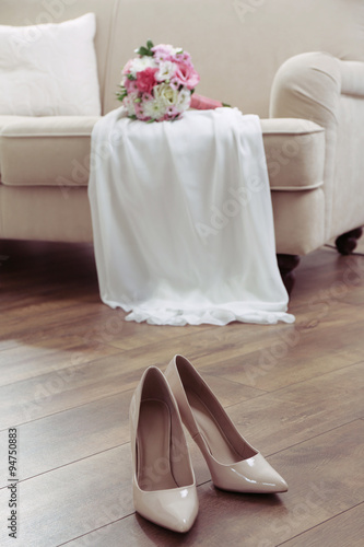 Wedding bouquet, bridesmaid dress and shoes in room