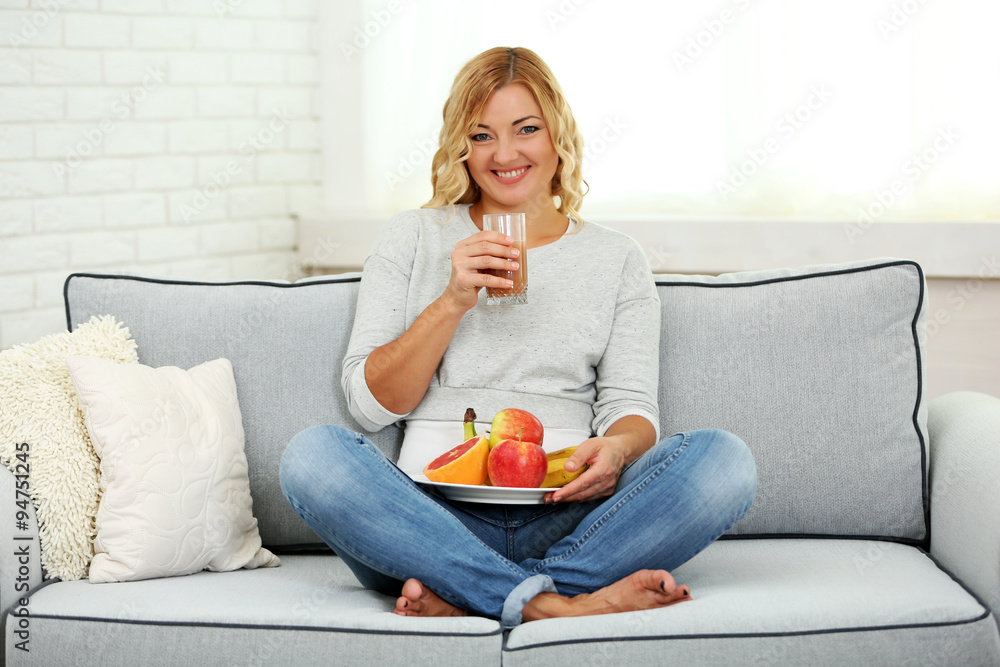Beautiful woman with fresh fruits  on home interior background
