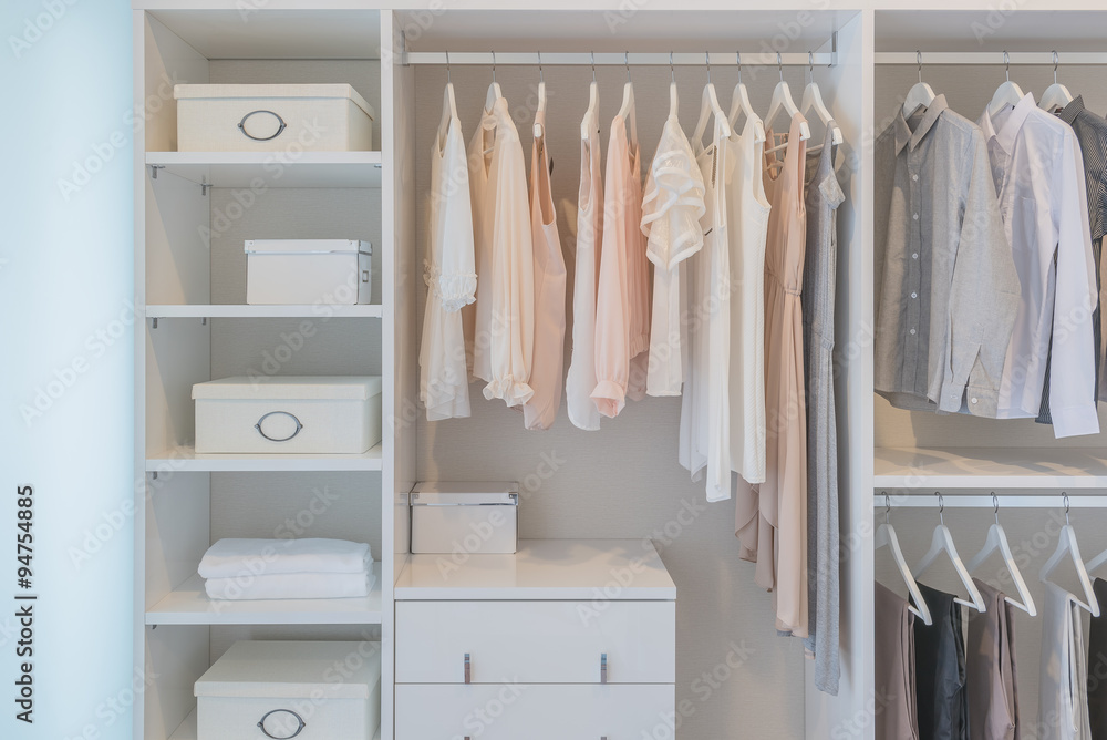 clothes hanging on rail in white wardrobe