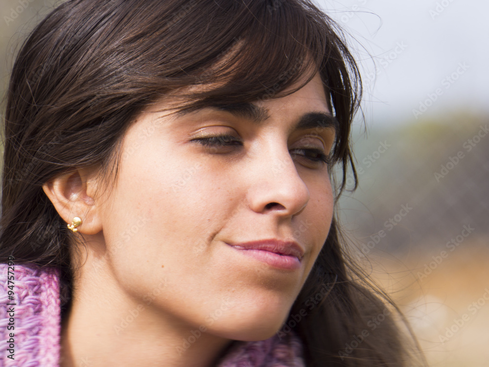 Foto de Mujer morena española de perfil en la oscuridad observa do Stock