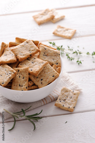 crackers with herbs and black sesame seeds on white table 