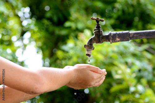 Little hand wait for water drop from faucet