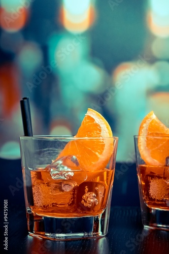 glasses of spritz aperitif aperol cocktail with orange slices and ice cubes on bar table, pop style atmosphere background
