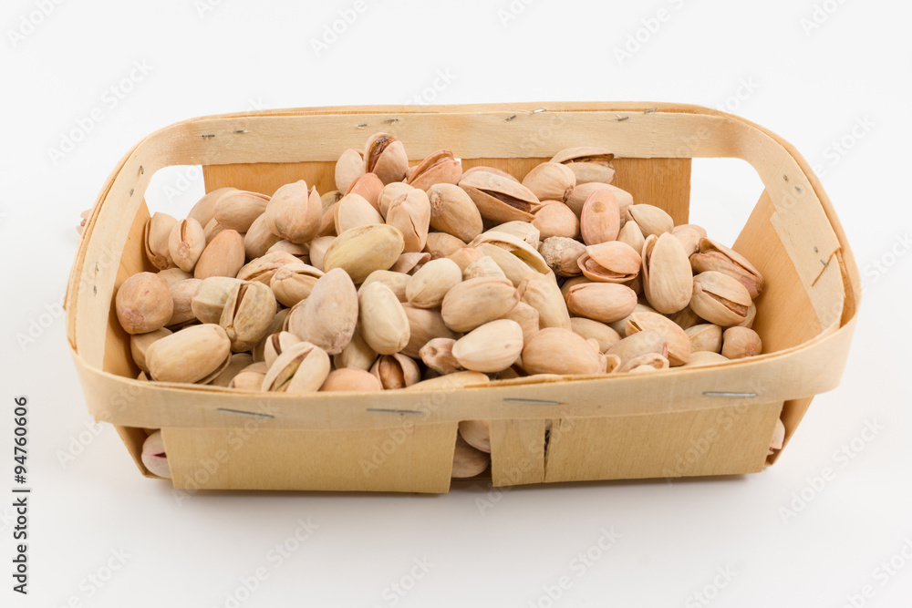 wooden container is filled with pistachios on a white background wooden container is filled with pistachios on a white background