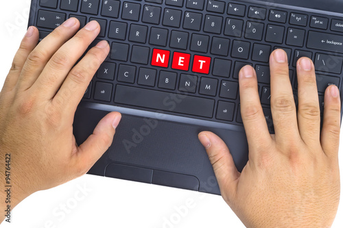 Hands on laptop with "NET" word on keyboard buttons against white background.