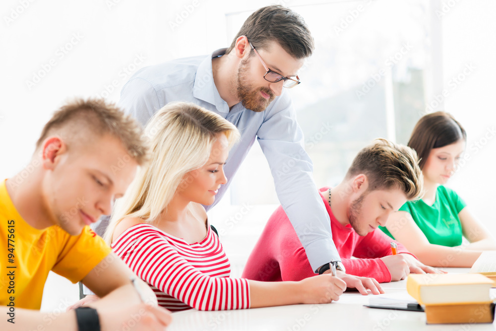 Group of teenage students studying at the lesson in the classroom Group of teenage students studying at the lesson in the classroom