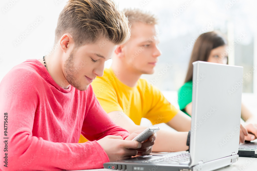 Student writing sms at the programming lesson Student writing sms at the programming lesson