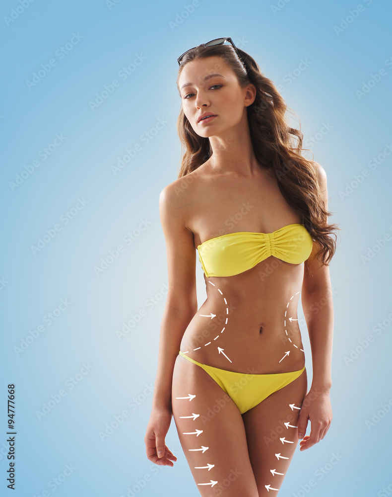 Fototapeta premium Stock photo of young, fit and sexy woman in yellow swimsuit