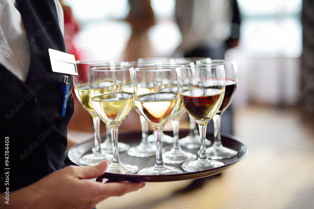 Waitress with dish of champagne and wine glasses