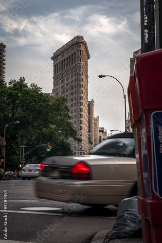 New York street during the day with a taxi cab takin a right turn