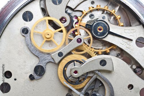 Metal cogwheels inside clockwork. Conceptual macro photo.