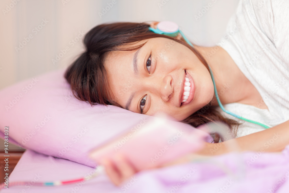 Asian young attractive girl lying on bed smile wear headphones Asian young attractive girl lying on bed smile wear headphones