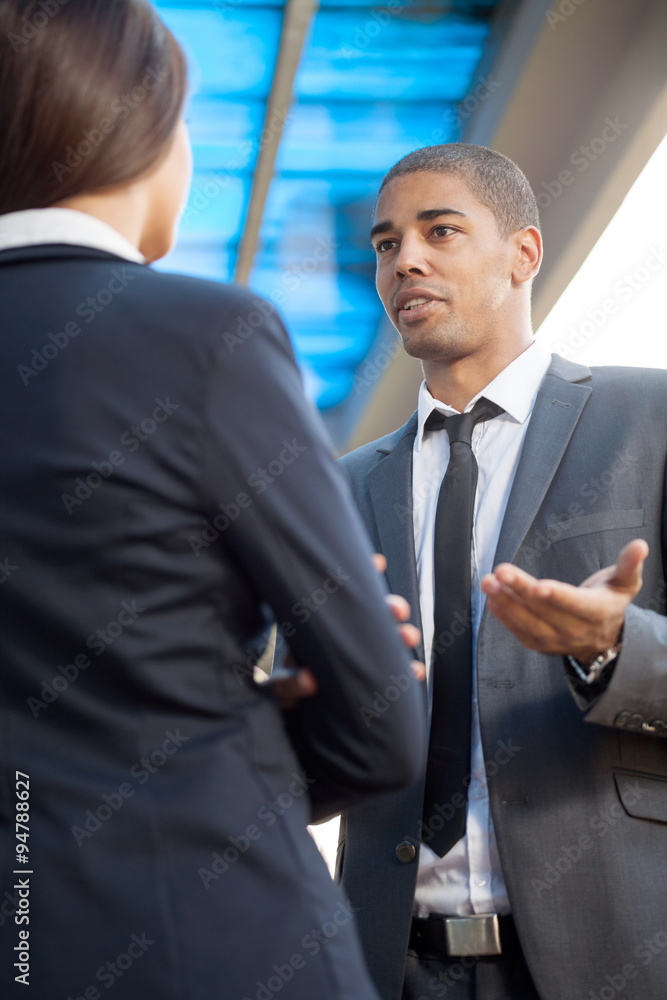 Fototapeta premium Businessman explaining colleague about work, outdoors