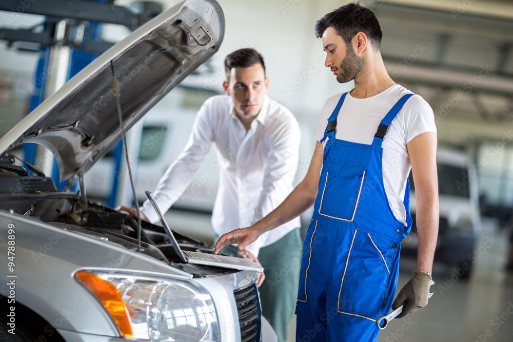 Client and employee looking diagnostic on engine Client and employee looking diagnostic on engine