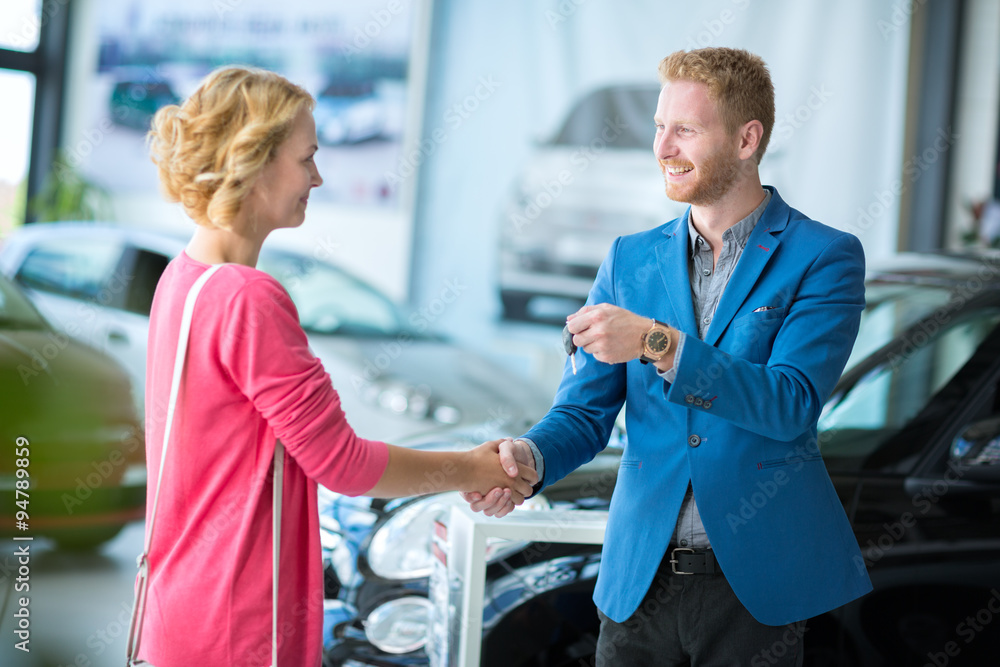 Fototapeta premium woman getting car keys from a car seller
