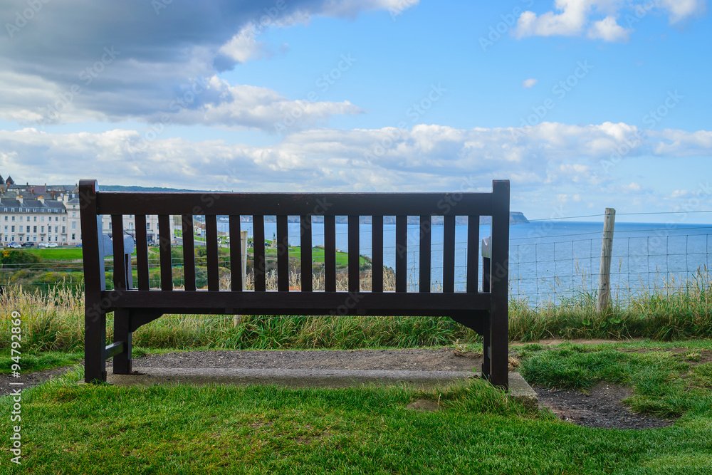 Wooden bench with the look at blue sea and the horizon in Whitby Abbey, North Yorkshire, UK