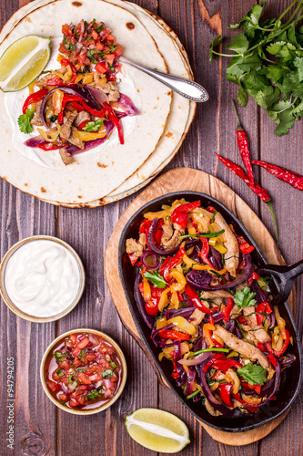 Pork fajitas with onions and colored pepper, served with tortill photo