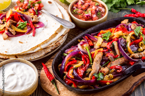 Konstfotografi Pork fajitas with onions and colored pepper, served with tortill