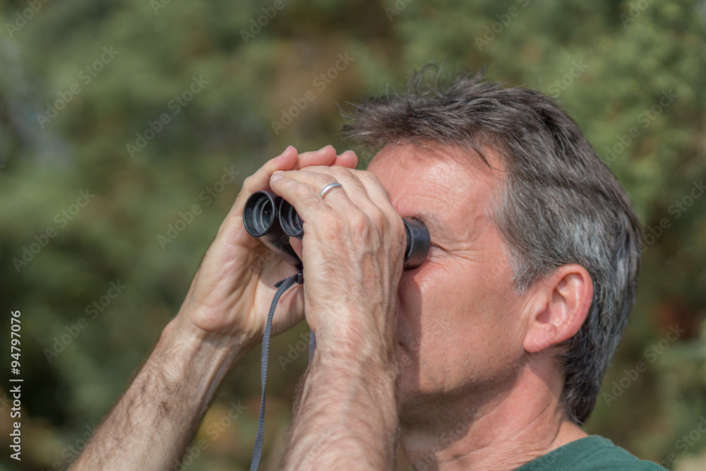 Senior man looking through binoculars Senior man looking through binoculars