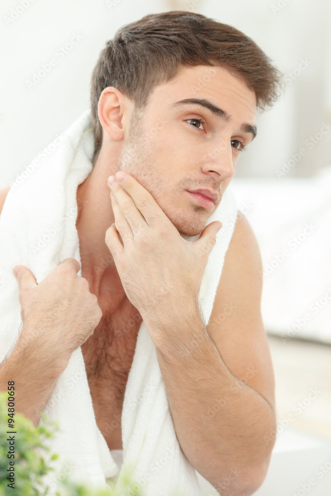 Fototapeta premium Attractive young guy is analyzing his appearance