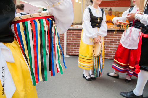 Girl with a typical regional dress holding a colored tambourine during a folkloristic show 