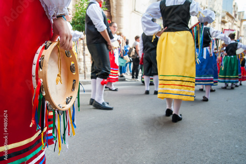 Girl with a typical regional dress holding a colored tambourine during a folkloristic show 