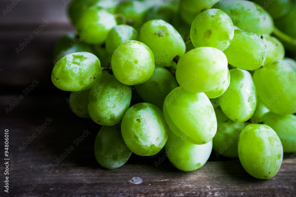 Vine of green grapes on rustic wooden background Vine of green grapes on rustic wooden background