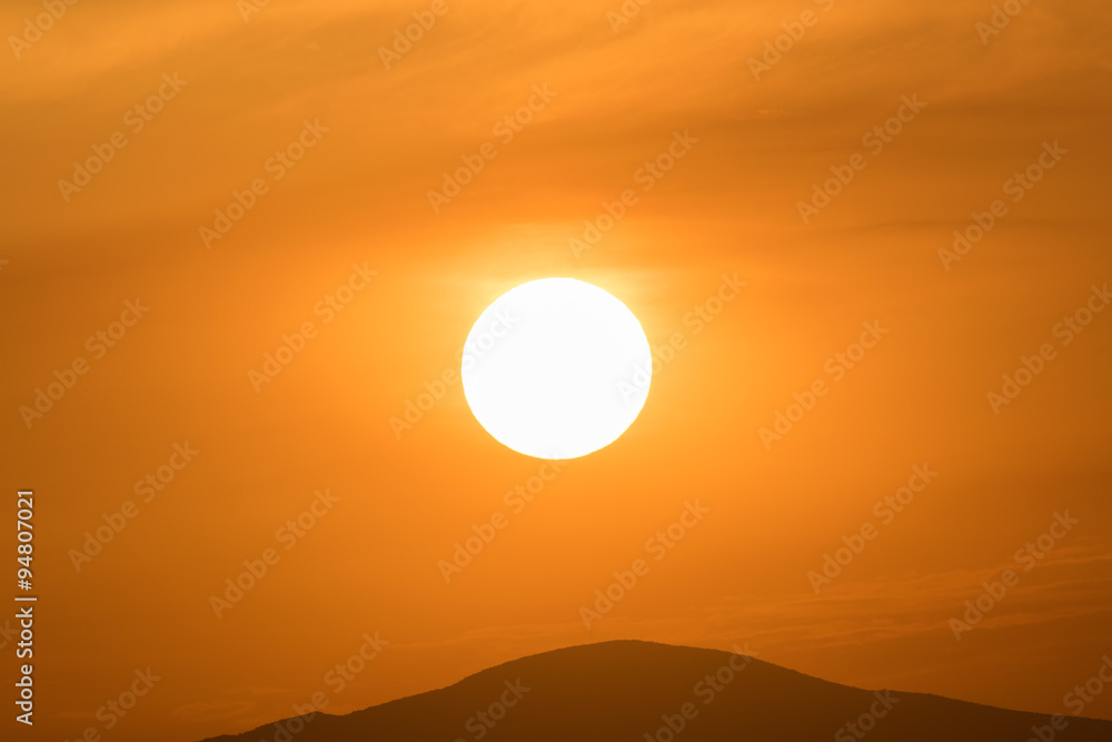 Close up of the sun against the mountains.
