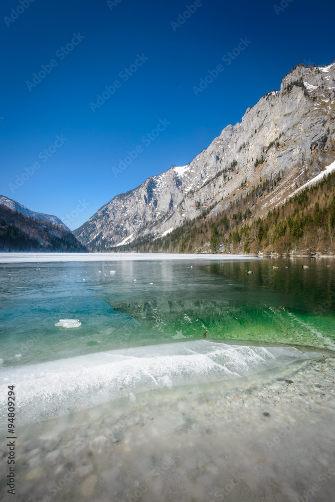 Winter landscape with frozen lake and mountains in background.Leopoldsteinersee,Styria,Austria. Winter landscape with frozen lake and mountains in background.Leopoldsteinersee,Styria,Austria.