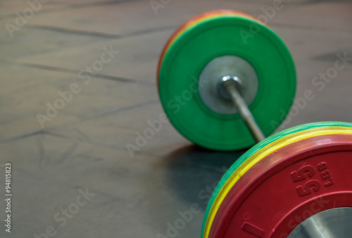 Barbell with red, yellow, and green weight plates 