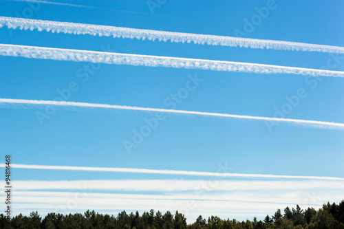 Chemtrails on blue sky photo