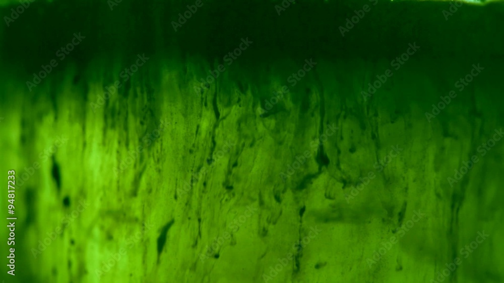 Hard particles dissolute in liquid; HD 1080 closeup footage; green color cast Hard particles dissolute in liquid; HD 1080 closeup footage; green color cast