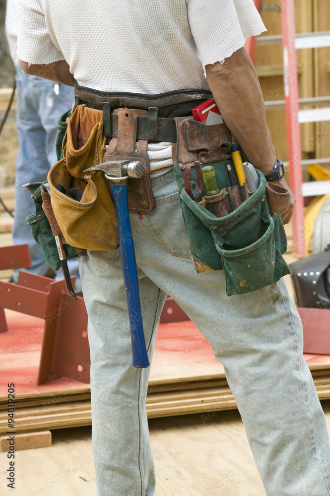 Tool belt of carpenter working on the framing process of home