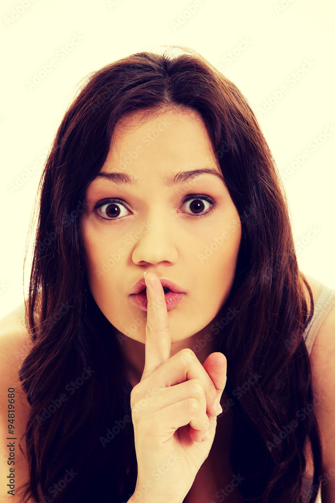 Young woman with finger on lips. Young woman with finger on lips.
