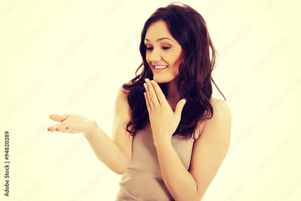 Young laughing woman holding copy space in hand. Young laughing woman holding copy space in hand.