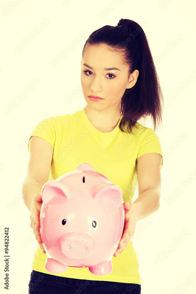 Unhappy woman holding piggybank. Unhappy woman holding piggybank.
