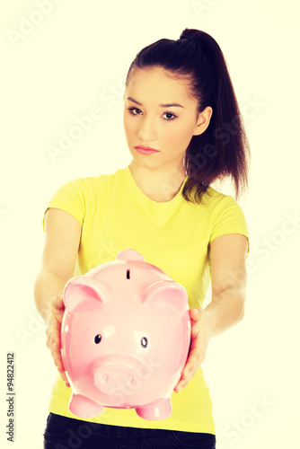 Unhappy woman holding piggybank.