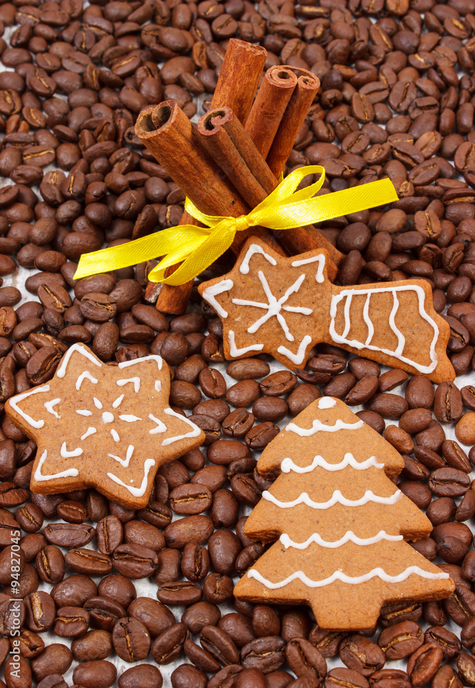 Decorated gingerbread and cinnamon sticks on coffee grains, christmas time Decorated gingerbread and cinnamon sticks on coffee grains, christmas time
