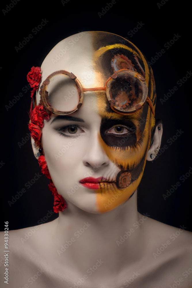 Bald girl with a art make up and steampunk glasses, on the one hand a mechanical robot, on the other blooming desert