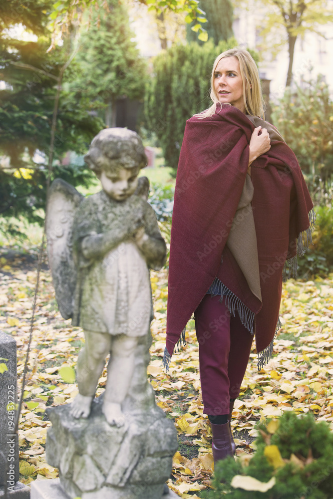 woman next to a grave with an angel woman next to a grave with an angel