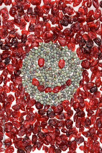 Smiling face mosaic made of cranberry and green pepper