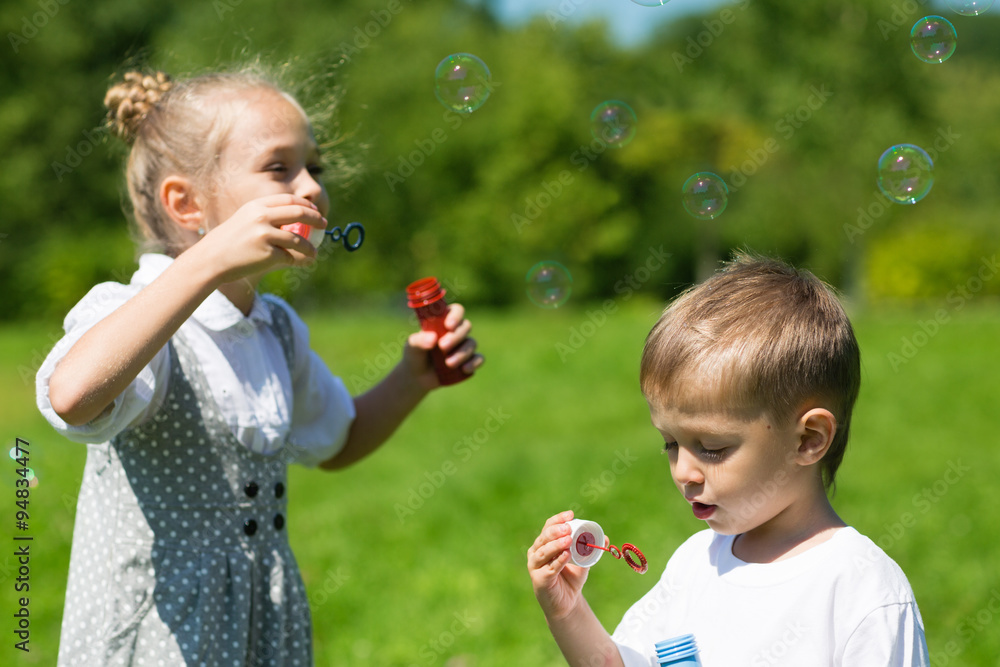 Lovely kids blow bubbles in the park Lovely kids blow bubbles in the park