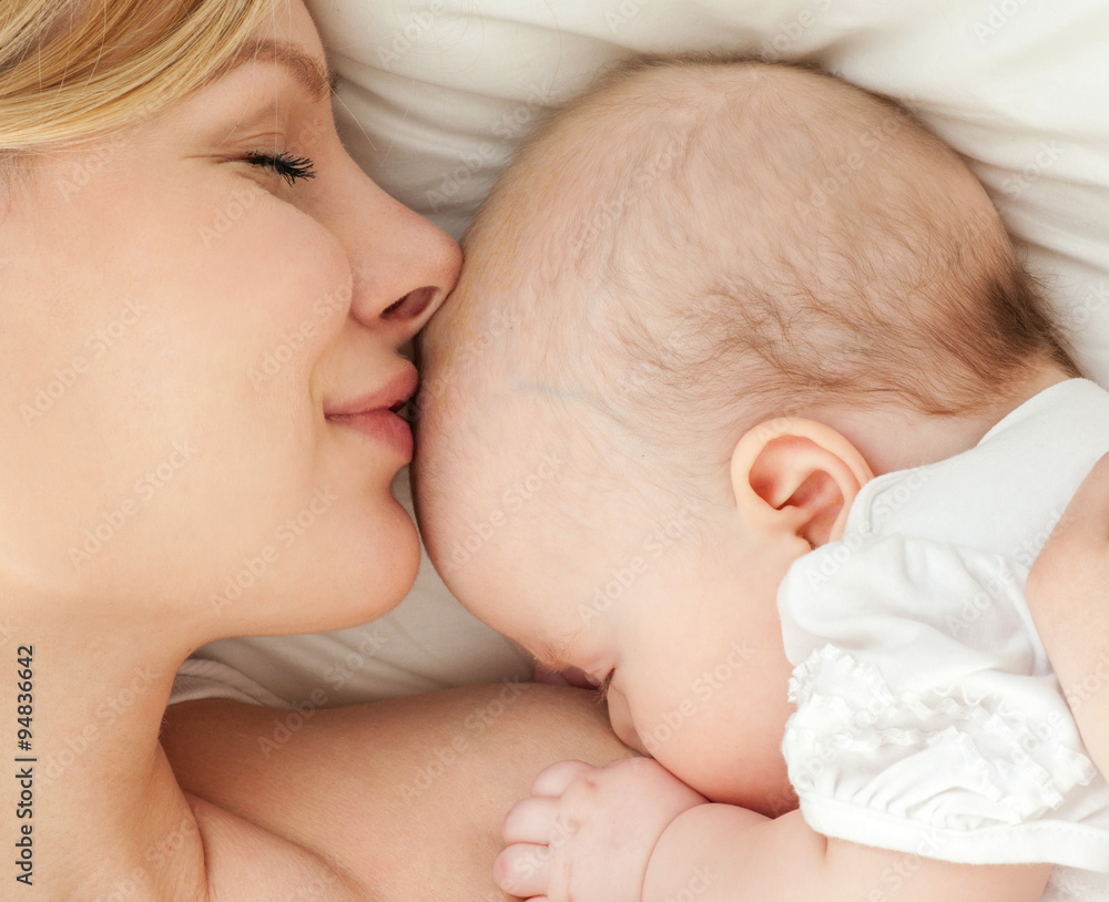 Young mother and her baby, sleeping in bed. Mother and baby. Young mother and her baby, sleeping in bed. Mother and baby.