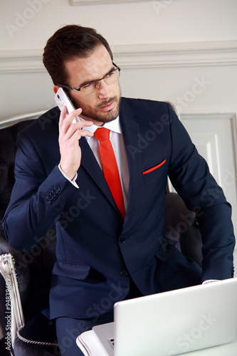 Biznesmen w biurze podczas rozmowy telefonicznej.