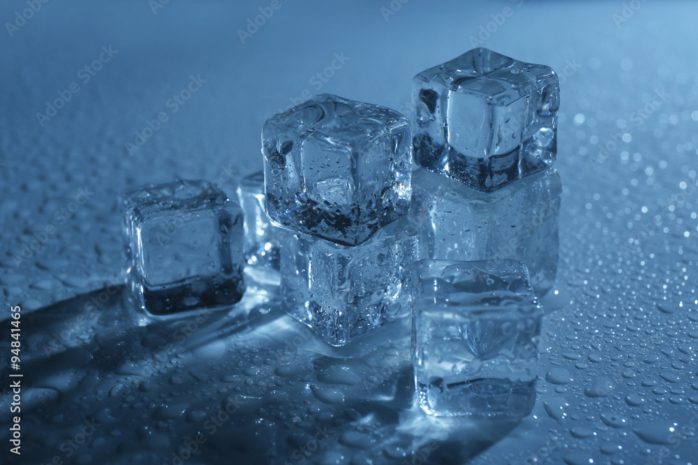 Melting ice cubes under blue light, close up Melting ice cubes under blue light, close up