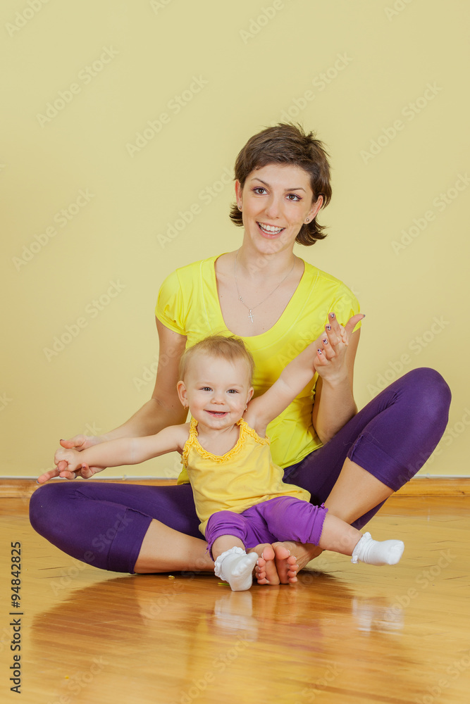 Mother does physical exercises with her daughter at home Mother does physical exercises with her daughter at home