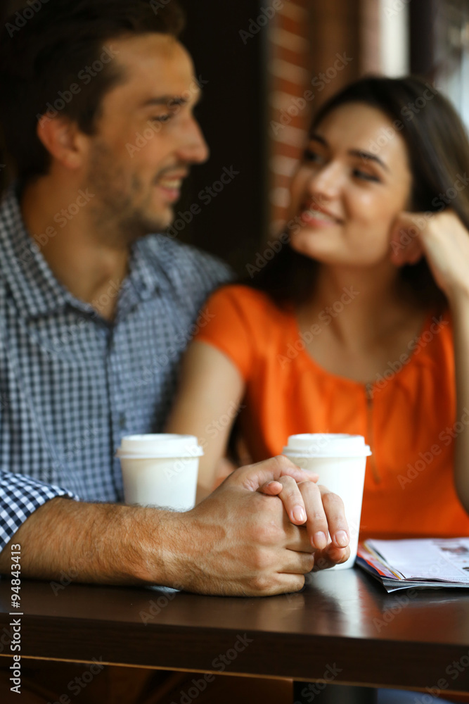 Young couple drink coffee in cafe outdoors