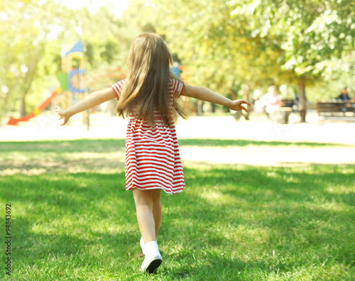 Little happy girl playing in park near the playground © Africa Studio