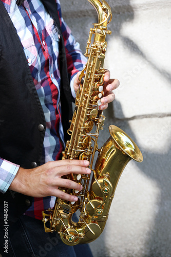 Saxophonist plays jazz outdoors, close up